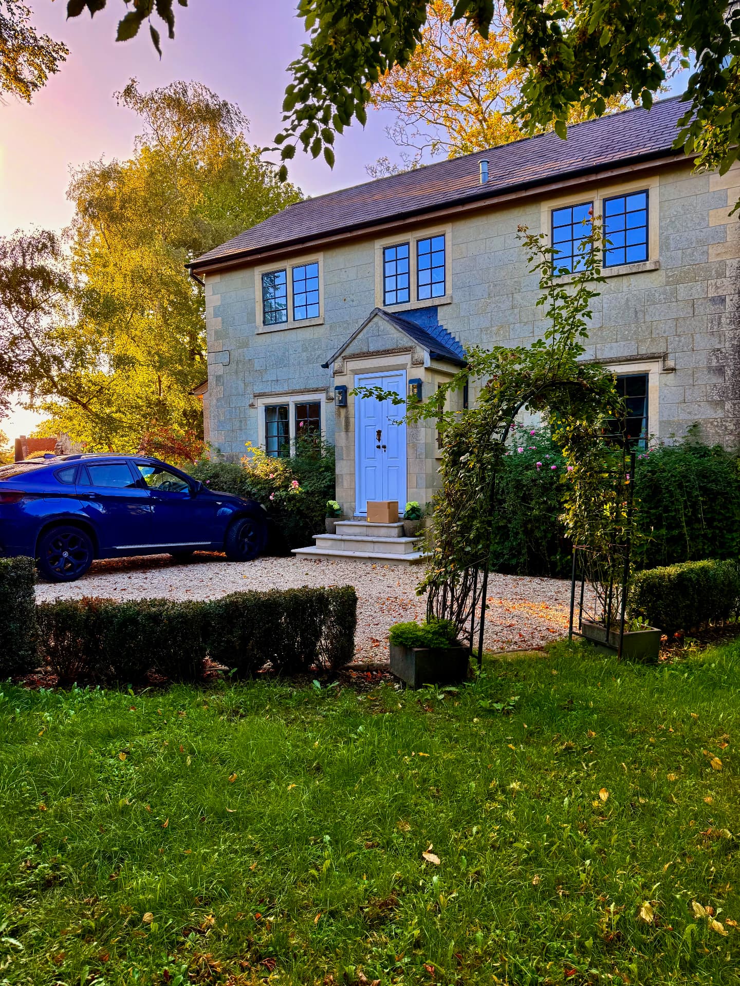 Stone house with a pale blue front door at sunset